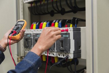 Elektrik mühendisi, kabine kontrolündeki voltaj ve elektrik hattının akımını ölçen bir testçi..