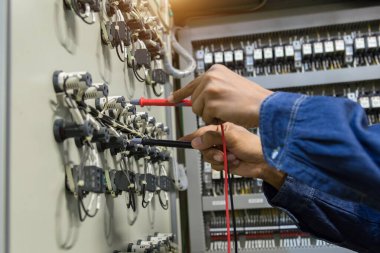 Elektrik mühendisi, kabine kontrolündeki voltaj ve elektrik hattının akımını ölçen bir testçi..