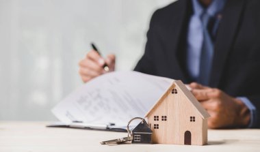 Buy or Rent 'le çalışan iş adamı, kopyalama alanı. Mülk yatırımı ve ev kredisi finansal konsepti El 'in ahşap eve para yığını koyması..