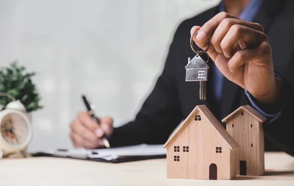 Buy or Rent 'le çalışan iş adamı, kopyalama alanı. Mülk yatırımı ve ev kredisi finansal konsepti El 'in ahşap eve para yığını koyması..
