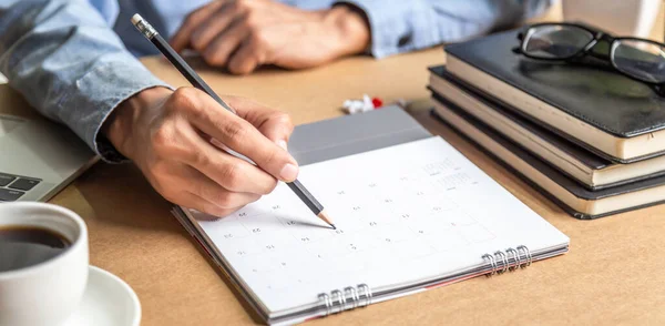 Businessman agenda calendar and reminder agenda work online at home men plan daily appointments and vacation travel journals in a diary at their desk . calendar reminder event concept .