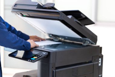 İşadamı, yazıcı fotokopi ağı panelindeki düğmeye basar, ofis konseptinde fotokopi üzerinde çalışır, yazıcı, kağıt tarama ve kopyalama için ofis çalışanı ekipmanıdır.