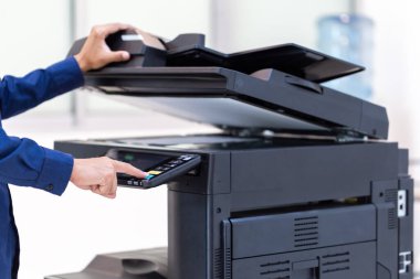 İşadamı, yazıcı fotokopi ağı panelindeki düğmeye basar, ofis konseptinde fotokopi üzerinde çalışır, yazıcı, kağıt tarama ve kopyalama için ofis çalışanı ekipmanıdır.
