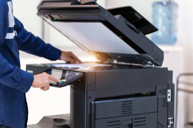 İşadamı, yazıcı fotokopi ağı panelindeki düğmeye basar, ofis konseptinde fotokopi üzerinde çalışır, yazıcı, kağıt tarama ve kopyalama için ofis çalışanı ekipmanıdır.