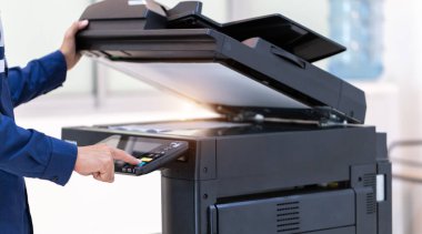 İşadamı, yazıcı fotokopi ağı panelindeki düğmeye basar, ofis konseptinde fotokopi üzerinde çalışır, yazıcı, kağıt tarama ve kopyalama için ofis çalışanı ekipmanıdır.