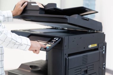 İşadamı, yazıcı fotokopi ağı panelindeki düğmeye basar, ofis konseptinde fotokopi üzerinde çalışır, yazıcı, kağıt tarama ve kopyalama için ofis çalışanı ekipmanıdır.