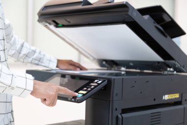 İşadamı, yazıcı fotokopi ağı panelindeki düğmeye basar, ofis konseptinde fotokopi üzerinde çalışır, yazıcı, kağıt tarama ve kopyalama için ofis çalışanı ekipmanıdır.