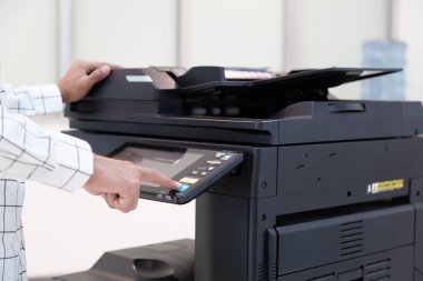 İşadamı, yazıcı fotokopi ağı panelindeki düğmeye basar, ofis konseptinde fotokopi üzerinde çalışır, yazıcı, kağıt tarama ve kopyalama için ofis çalışanı ekipmanıdır.