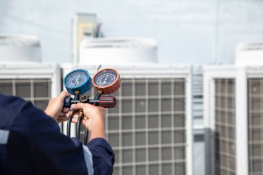 Teknisyen klimayı kontrol ediyor, klimaları, servis ve bakım klimalarını doldurmak için ölçüm aletleri kullanıyor. .