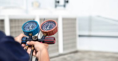 Teknisyen klimayı kontrol ediyor, klimaları, servis ve bakım klimalarını doldurmak için ölçüm aletleri kullanıyor. .