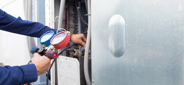 Technician is checking air conditioner ,measuring equipment for filling air conditioners.