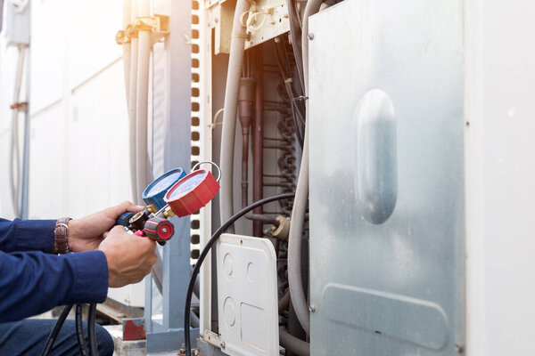 Technician is checking air conditioner ,measuring equipment for filling air conditioners.