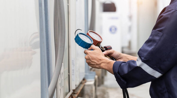 Technician is checking air conditioner ,measuring equipment for filling air conditioners.