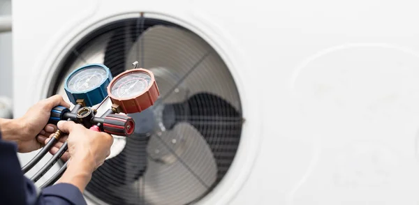 Teknisyen klimayı kontrol ediyor, klimaları doldurmak için ekipmanları ölçüyor..