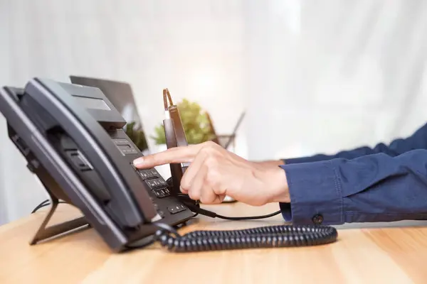 Call center staff man hand point to press the button number on the phone office desk , Communication support, call center and customer service help desk. for (call center) concept