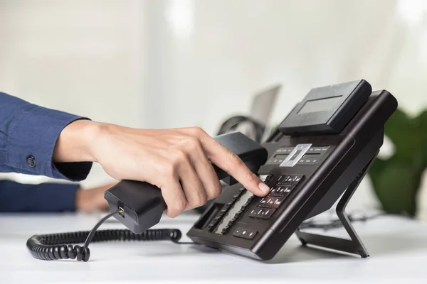 Call center staff man hand point to press the button number on the phone office desk , Communication support, call center and customer service help desk. for (call center) concept