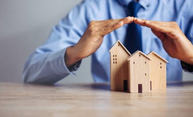 Sigorta evi ve aile sağlığı konsepti. Sigorta acentesi kapsamayı sembolize eden el koruma modelini sunar. .