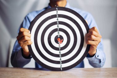 Hedef iş merkezi iş hedefi kavramını hedef alan bir dart tutan işadamı - iş hedefleme, nişan alma, odaklanma konsepti, pazarlamayı hedeflemek için metafor veya ticari başarı için hedef ok.