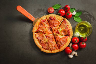 Acı biberli pizza, lezzetli biberli pizza ve siyah arka planda domates fesleğeni..