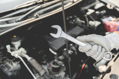 Otomobil tamircisi elleri ingiliz anahtarı, araba servisi ve bakımı ile bir araba motoru otomotiv atölyesini tamir ediyor..