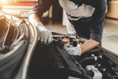 Otomobil tamircisi elleri ingiliz anahtarı, araba servisi ve bakımı ile bir araba motoru otomotiv atölyesini tamir ediyor..