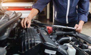 Otomobil tamircisi elleri ingiliz anahtarı, araba servisi ve bakımı ile bir araba motoru otomotiv atölyesini tamir ediyor..