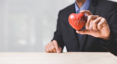 Sağlık, tıp, insanlar ve kardiyoloji konsepti - küçük kırmızı kalp üzerinde kardiyogramı olan mutlu adama yakın çekim