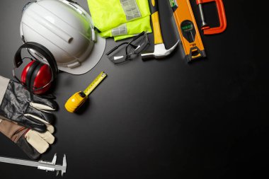 İş güvenliği. Ahşap arka planda inşaat alanı koruyucu ekipman, düz döşeme, kopyalama alanı, üst görünüm