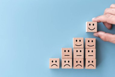 Üst görünümü kapat. Tahta küpten gülen yüz seç. Hizmet derecesi, tatmin konsepti..