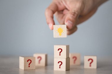 Elle düzenleme ahşap blok ikon soru işareti ve lamba ile istifleme, düşünce soru işareti kavramı.