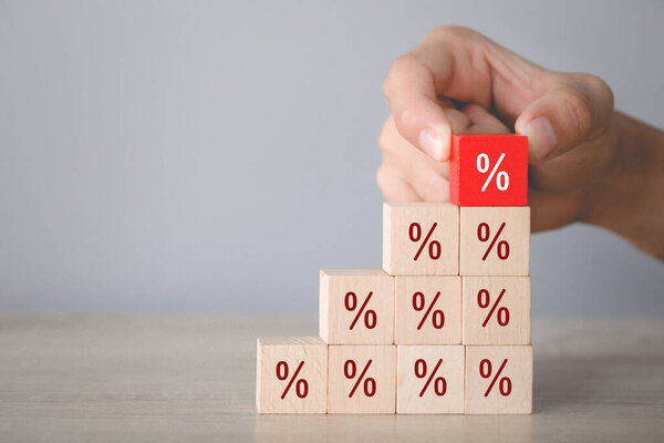 Hand arranging wood block stacking with icon percent symbol upward direction,