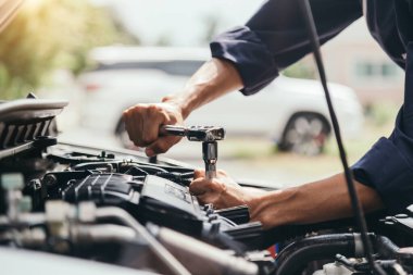 Otomobil tamircisi elleri ingiliz anahtarı, araba servisi ve bakımı ile bir araba motoru otomotiv atölyesini tamir ediyor..