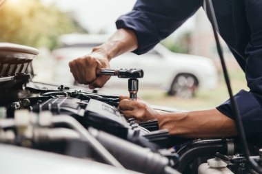 Otomobil tamircisi elleri ingiliz anahtarı, araba servisi ve bakımı ile bir araba motoru otomotiv atölyesini tamir ediyor..