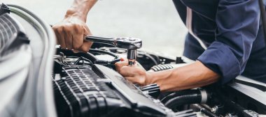 Otomobil tamircisi elleri ingiliz anahtarı, araba servisi ve bakımı ile bir araba motoru otomotiv atölyesini tamir ediyor..