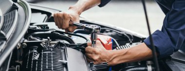 Otomobil tamircisi elleri ingiliz anahtarı, araba servisi ve bakımı ile bir araba motoru otomotiv atölyesini tamir ediyor..