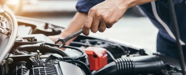 Otomobil tamircisi elleri ingiliz anahtarı, araba servisi ve bakımı ile bir araba motoru otomotiv atölyesini tamir ediyor..