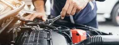 Otomobil tamircisi elleri ingiliz anahtarı, araba servisi ve bakımı ile bir araba motoru otomotiv atölyesini tamir ediyor..