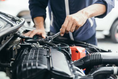 Otomobil tamircisi elleri ingiliz anahtarı, araba servisi ve bakımı ile bir araba motoru otomotiv atölyesini tamir ediyor..