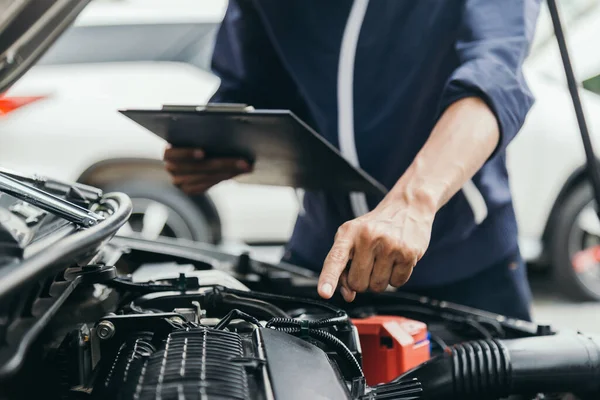 Otomobil tamircisi elleri ingiliz anahtarı, araba servisi ve bakımı ile bir araba motoru otomotiv atölyesini tamir ediyor..