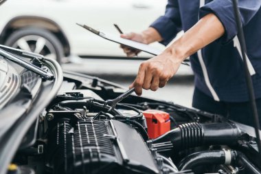 Otomobil tamircisi elleri ingiliz anahtarı, araba servisi ve bakımı ile bir araba motoru otomotiv atölyesini tamir ediyor..