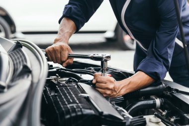 Otomobil tamircisi elleri ingiliz anahtarı, araba servisi ve bakımı ile bir araba motoru otomotiv atölyesini tamir ediyor..