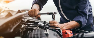 Otomobil tamircisi elleri ingiliz anahtarı, araba servisi ve bakımı ile bir araba motoru otomotiv atölyesini tamir ediyor..
