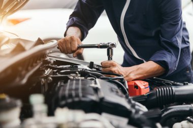 Otomobil tamircisi elleri ingiliz anahtarı, araba servisi ve bakımı ile bir araba motoru otomotiv atölyesini tamir ediyor..