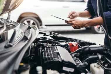 Otomobil tamircisi elleri ingiliz anahtarı, araba servisi ve bakımı ile bir araba motoru otomotiv atölyesini tamir ediyor..