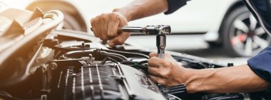 Otomobil tamircisi elleri ingiliz anahtarı, araba servisi ve bakımı ile bir araba motoru otomotiv atölyesini tamir ediyor..