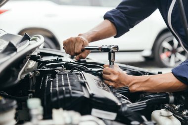 Otomobil tamircisi elleri ingiliz anahtarı, araba servisi ve bakımı ile bir araba motoru otomotiv atölyesini tamir ediyor..