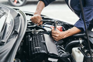 Otomobil tamircisi elleri ingiliz anahtarı, araba servisi ve bakımı ile bir araba motoru otomotiv atölyesini tamir ediyor..