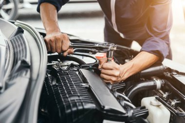 Otomobil tamircisi elleri ingiliz anahtarı, araba servisi ve bakımı ile bir araba motoru otomotiv atölyesini tamir ediyor..