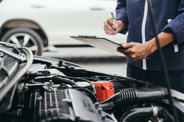 Otomobil tamircisi elleri ingiliz anahtarı, araba servisi ve bakımı ile bir araba motoru otomotiv atölyesini tamir ediyor..