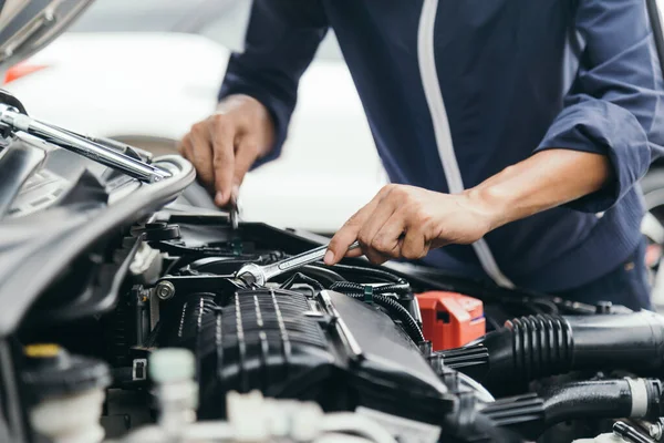 Automobile mechanic repairman hands repairing a car engine automotive workshop with a wrench, car service and maintenance,Repair service.